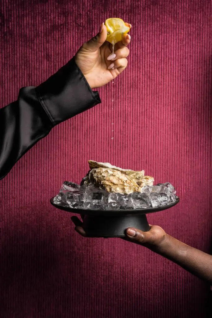 Citroensap wordt uitgeknepen over een oester